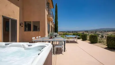 a hot tub on a patio with a table and chairs at Palazzo Del Sol By AvantStay Breathtaking Home w Mountain Views Hot Tub in Temecula