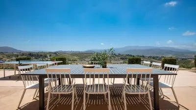 a table and chairs with a view of the mountains at Palazzo Del Sol By AvantStay Breathtaking Home w Mountain Views Hot Tub in Temecula