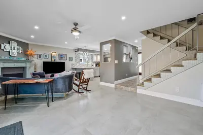 a living room with a table and a staircase at Sunsoak Shack in San Diego