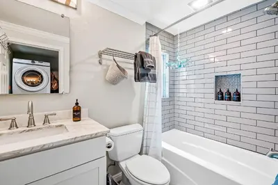 a bathroom with a toilet and a sink and a washing machine at Sunsoak Shack in San Diego