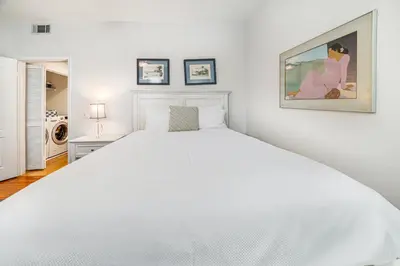 a white bedroom with a large white bed at Ocean Pointe Getaway - 30-Night Minimum in Carlsbad