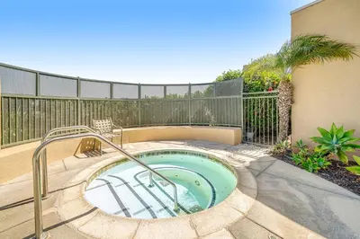 a hot tub in a patio with a fence at Ocean Pointe Getaway - 30-Night Minimum in Carlsbad