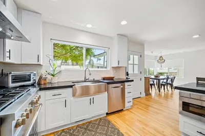 a kitchen with white cabinets and a large window at The Little Crab Shack in Dana Point