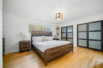 a bedroom with a large bed and wooden floors at The Little Crab Shack in Dana Point