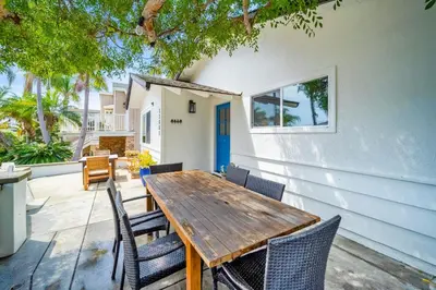 a wooden table and chairs in front of a house at The Little Crab Shack in Dana Point