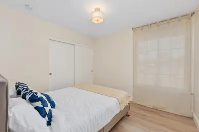 a white bedroom with a bed and a window at Golf - Beach - Legoland - Shopping - Dining in Carlsbad