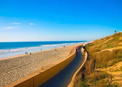 a beach with people walking on the sand and the ocean at Golf - Beach - Legoland - Shopping - Dining in Carlsbad