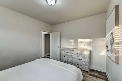 a bedroom with a white bed and a dresser at Walk to Poway Farmers Market Family Retreat! in Poway