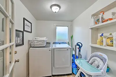 a small laundry room with a refrigerator and a chair at Walk to Poway Farmers Market Family Retreat! in Poway