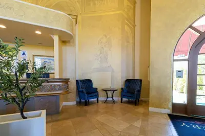 a waiting room with two blue chairs and a table at Inn at Churon Winery in Temecula