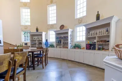 a dining room with a table and chairs and windows at Inn at Churon Winery in Temecula