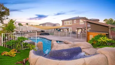 a backyard with a swimming pool and a slide at San Diego Luxury Oasis in Spring Valley