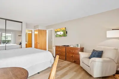 a bedroom with a white bed and a chair at Whitewater Village Retreat B in Oceanside