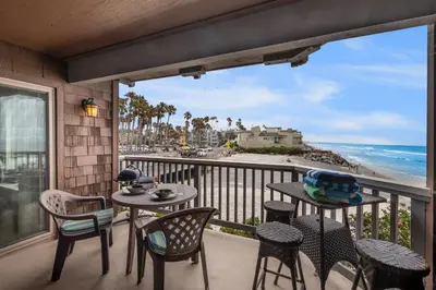 a balcony with a table and chairs and a view of the ocean at Whitewater Village Retreat B in Oceanside