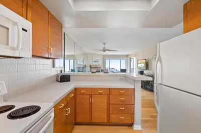a kitchen with wooden cabinets and white appliances at Whitewater Village Retreat B in Oceanside