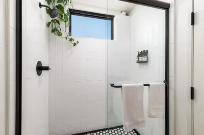 a bathroom with a shower with a glass door at The Brick Boutique Hotel in Oceanside