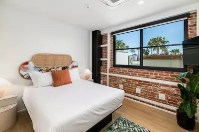 a bedroom with a bed and a brick wall at The Brick Boutique Hotel in Oceanside