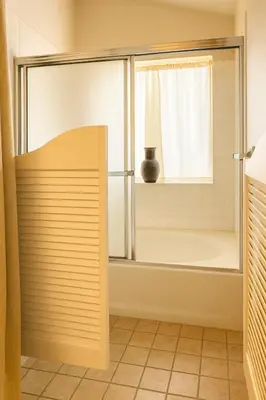 a bathroom with a shower with a window and a tub at Stallion Crest Suite with TV and private bathroom in Hemet