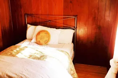 a bed with a pillow on it in a room at Historical Cabin in Julian Pet's okay! in Julian
