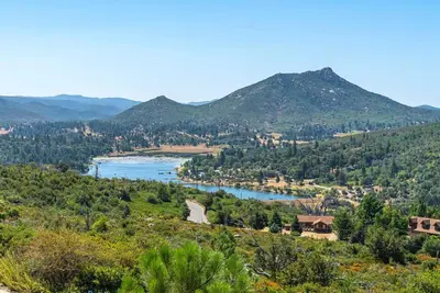 a view of a river with mountains in the background at A LIVING CANVAS Amazing Lake View Custom Home in Julian