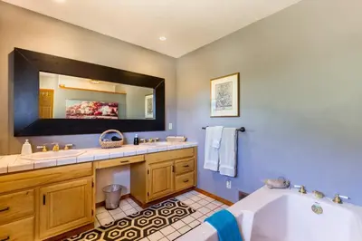 a bathroom with a tub and a large mirror at A LIVING CANVAS Amazing Lake View Custom Home in Julian