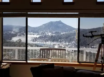 a view of a mountain through a large window at A LIVING CANVAS Amazing Lake View Custom Home in Julian
