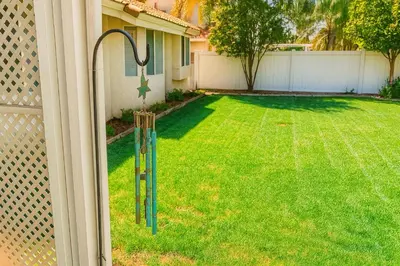a yard with a lawn with a fence and cricketickets at Sundance Retreat in Hemet