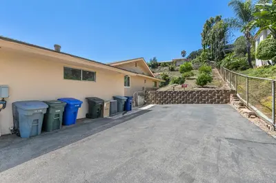 a house with several trash cans and a fence at Charming 2 Room La Mesa Casita w/ Pool, BBQ & Yard in La Mesa