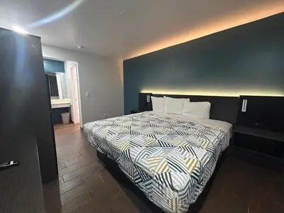 a bedroom with a bed with a black and white comforter at Studio 6 Hemet, CA in Hemet