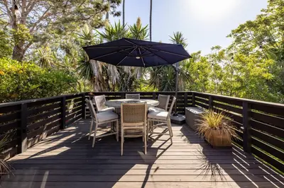 a table with chairs and an umbrella on a deck at Solana Beach House! Minutes to Dog Beach & Cedros in Solana Beach
