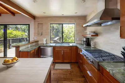 a large kitchen with wooden cabinets and a stove at Solana Beach House! Minutes to Dog Beach & Cedros in Solana Beach