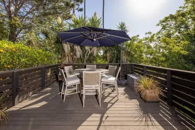 a table and chairs with an umbrella on a deck at Solana Beach House! Minutes to Dog Beach & Cedros in Solana Beach