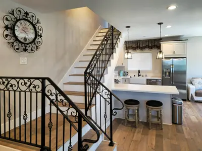 a kitchen and living room with a staircase with a clock at Modern comfort, prime location, 360 views, 4 BR entire house in San Diego