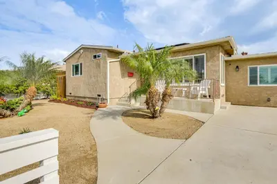 a house with a palm tree in front of it at Breeze by the Marina Chula Vista Getaway! in Chula Vista