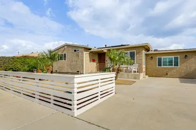 a house with a white fence in front of it at Breeze by the Marina Chula Vista Getaway! in Chula Vista