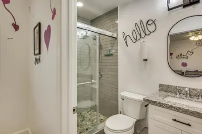 a bathroom with a toilet and a sink and a mirror at Breeze by the Marina Chula Vista Getaway! in Chula Vista