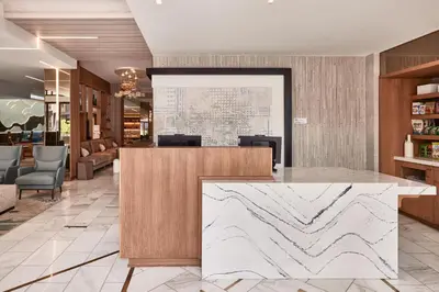 a lobby with a marble counter in the middle at AC Hotel by Marriott San Diego Downtown Gaslamp Quarter in San Diego