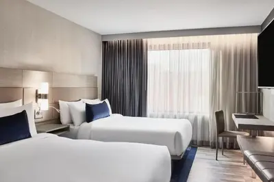a hotel room with two beds and a desk at AC Hotel by Marriott San Diego Downtown Gaslamp Quarter in San Diego