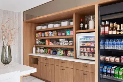 a kitchen with a refrigerator filled with lots of drinks at AC Hotel by Marriott San Diego Downtown Gaslamp Quarter in San Diego