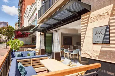 an outdoor patio with tables and chairs and a restaurant at AC Hotel by Marriott San Diego Downtown Gaslamp Quarter in San Diego