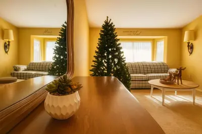 a living room with a christmas tree and a mirror at Rosewood Retreat in Hemet