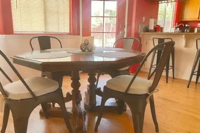 a dining room table with chairs and a table with scissors on it at Rosewood Retreat in Hemet