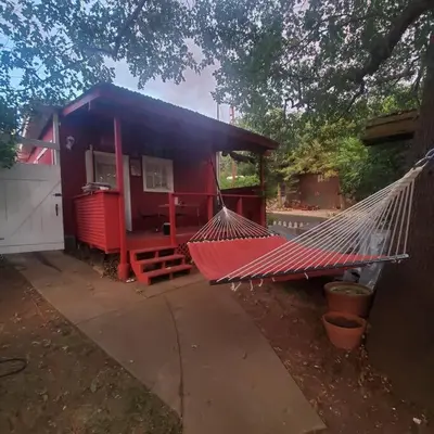 a red house with a hammock in front of it at Cozy, Cheerful & Charming Cabin - Historic Julian in Julian