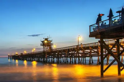 a pier with a lighthouse on the water at night at Blue Whale Inn San Clemente Retreat Unit E in San Clemente
