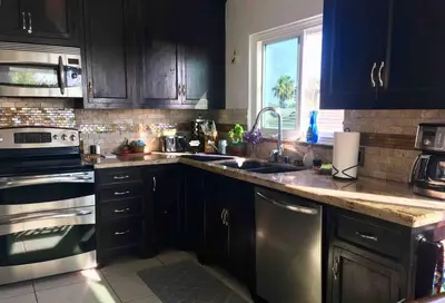 a kitchen with black cabinets and stainless steel appliances at Blue Whale Inn San Clemente Retreat Unit E in San Clemente