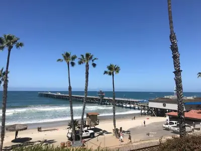 a beach with palm trees and a pier at Blue Whale Inn San Clemente Charmer Unit A in San Clemente