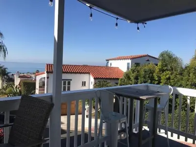 a deck with a table and chairs on a balcony at Blue Whale Inn San Clemente Charmer Unit A in San Clemente