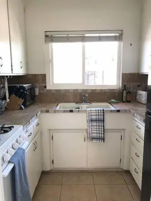 a kitchen with white cabinets and a sink and a window at Blue Whale Inn San Clemente Charmer Unit A in San Clemente