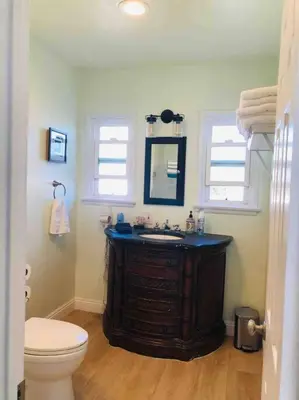 a bathroom with a sink and a toilet and two windows at Blue Whale Inn San Clemente Jewel Unit D in San Clemente
