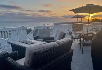 a balcony with chairs and tables and an umbrella at Blue Whale Inn San Clemente Jewel Unit D in San Clemente